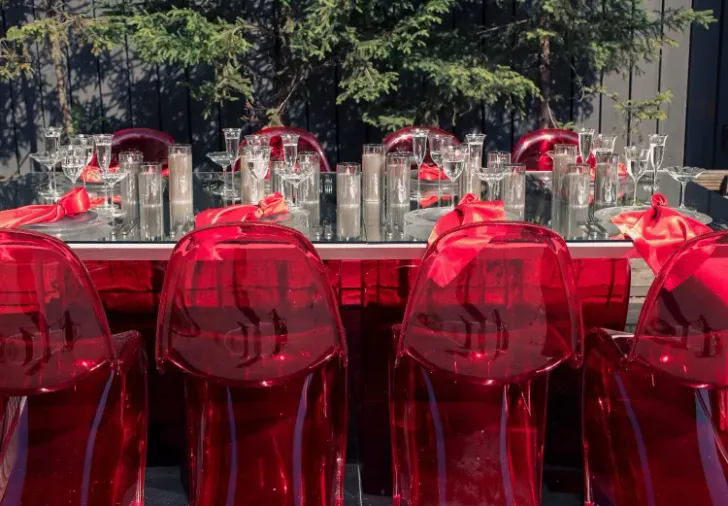 Прозрачно-дымчатый сет с красными акцентами за белым зеркальным прямоугольным столом