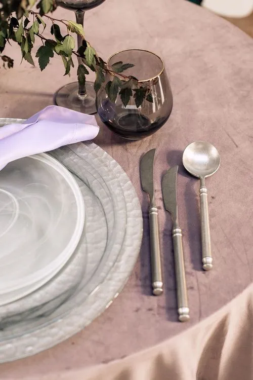 Серебрянная сервировка на лиловой бархатной скатерти