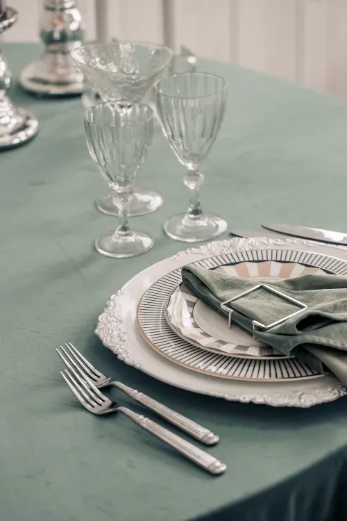 Сервировка в зеленых тонах за круглым столом